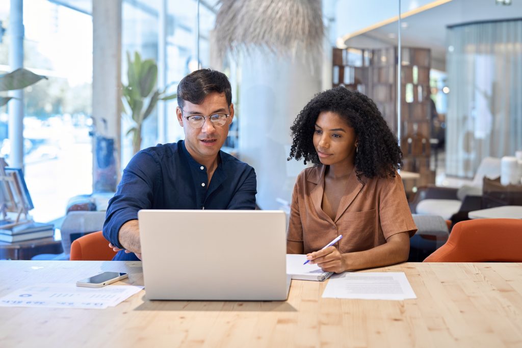 Two professionals reviewing a website together on a laptop.