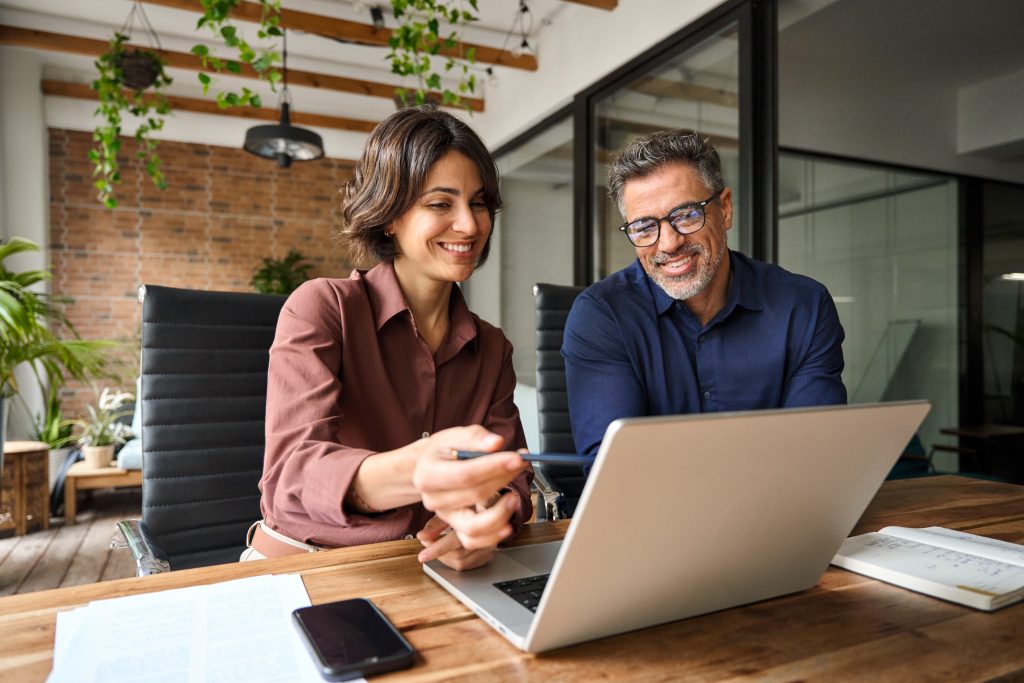 Two professionals reviewing a website together on a laptop.